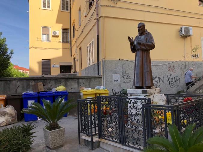 images Catanzaro. Un lettore segnala: "Cassonetti stracolmi proprio davanti alla statua di san Pio da Pietrelcina"